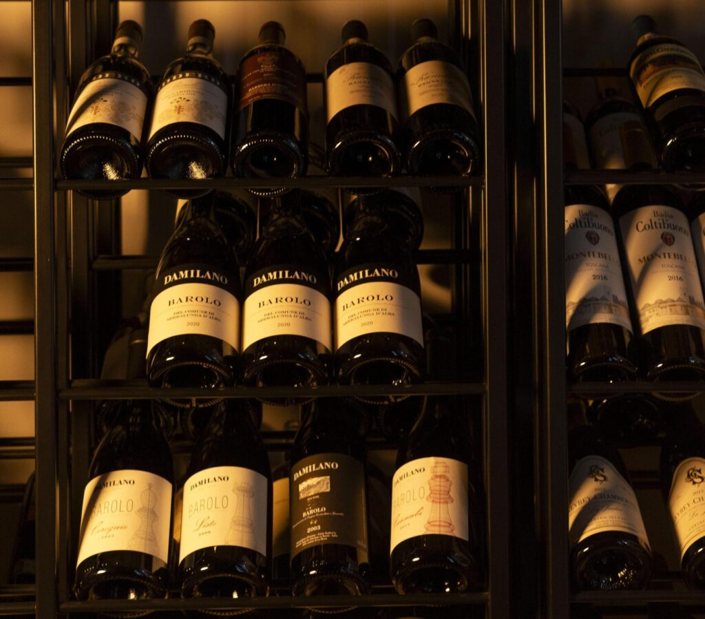 Dettaglio di bottiglie di vino nella cantina di Villa Carona, ideali per cene private e degustazioni