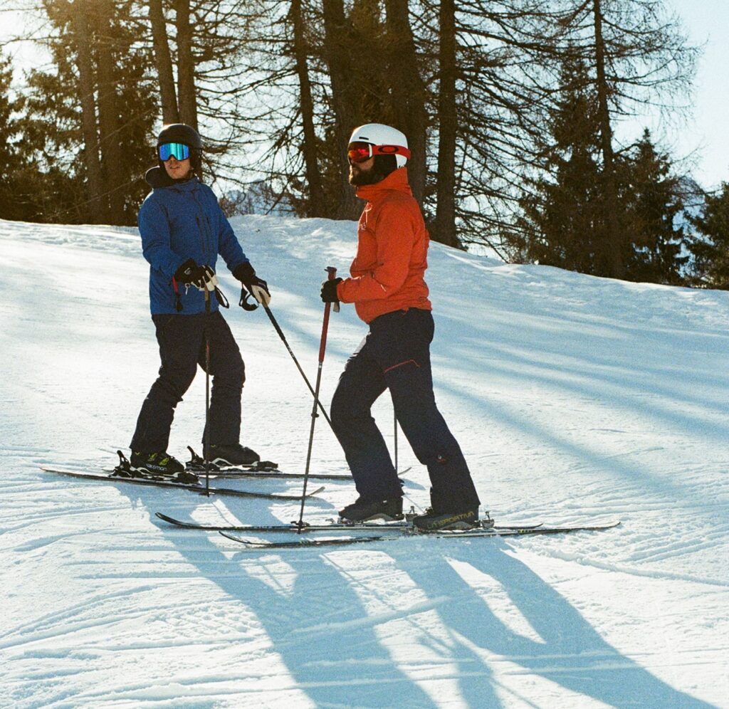 Attività all'aperto : due sciatori sulle piste della Val Brembana vicino a Hotel Villa Carona, tra i boschi innevati