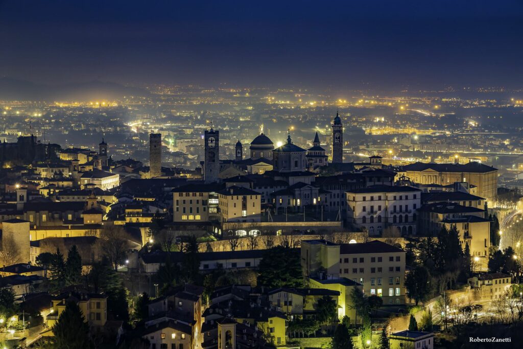 Panorama notturno di Bergamo Alta con i campanili e le mura storiche illuminate