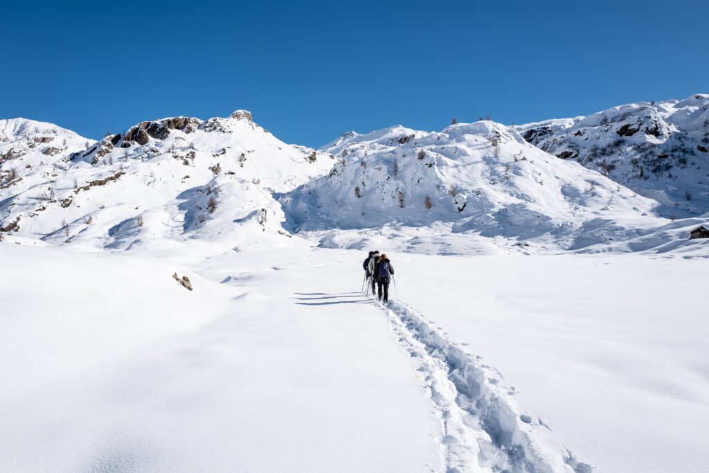 Attività all'aperto : escursionisti con le ciaspole su un sentiero innevato in Val Brembana, partenza da Carona